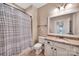 This bathroom offers a granite vanity, tile floors, tub with curtain and white cabinets at 1600 Buckland Ct, Indian Land, SC 29707