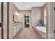 Spacious bathroom with double vanity, soaking tub, and open doorway to bedroom at 1600 Buckland Ct, Indian Land, SC 29707