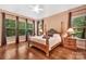 Primary bedroom with hardwood floors, lots of windows, and an elegant four-poster bed at 1600 Buckland Ct, Indian Land, SC 29707