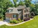 Brick home with a well-manicured lawn, attached garage and mature trees at 1600 Buckland Ct, Indian Land, SC 29707