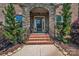 Charming front entrance featuring stone archway, brick steps, and landscaped surroundings at 1600 Buckland Ct, Indian Land, SC 29707
