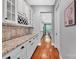 Hallway with hardwood floors, white cabinets, and granite countertops leading to an eat-in kitchen at 1600 Buckland Ct, Indian Land, SC 29707