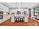 Spacious kitchen island featuring a granite countertop, white cabinetry, pendant lighting, and hardwood floors at 1600 Buckland Ct, Indian Land, SC 29707