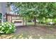 Lush backyard featuring a wooden pergola-covered deck with swing, mature trees, and flowering bushes at 1817 Tradd Ave, Clover, SC 29710