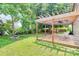 Serene backyard with a pergola-covered deck, a fire pit, and lush green grass, ideal for outdoor living at 1817 Tradd Ave, Clover, SC 29710