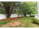 Backyard featuring a lush lawn, mature trees, and a well-maintained white fence at 18715 Coachmans Trce, Cornelius, NC 28031