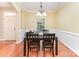 Formal dining room featuring hardwood floors, decorative trim, a window with blinds, and a dining table at 18715 Coachmans Trce, Cornelius, NC 28031