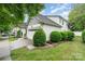 Charming home featuring white siding, a two-car garage, well-manicured landscaping and a cozy front porch at 18715 Coachmans Trce, Cornelius, NC 28031