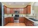 Well-equipped kitchen featuring wood cabinets, stainless steel appliances, granite countertops, and hardwood floors at 18715 Coachmans Trce, Cornelius, NC 28031