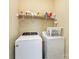 Efficient laundry room with washer, dryer, and storage shelving at 18715 Coachmans Trce, Cornelius, NC 28031