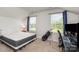 Neutral-toned bedroom with two windows, a golf bag, and a desk area at 218 Canina Ln, Indian Trail, NC 28079