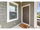 Inviting front entry featuring a stylish door, a welcome mat, and modern siding, complemented by a bright window at 218 Canina Ln, Indian Trail, NC 28079