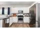 Stylish kitchen with stainless steel appliances, granite countertops, white cabinets, and wood-look flooring at 218 Canina Ln, Indian Trail, NC 28079