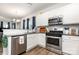Well-lit kitchen featuring stainless steel appliances, granite countertops, white cabinets, and wood-look flooring at 218 Canina Ln, Indian Trail, NC 28079