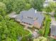 Sprawling brick home with landscaped grounds featuring a covered patio, basketball court, and outdoor kitchen at 2300 Richardson Dr, Charlotte, NC 28211