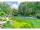 Beautifully landscaped backyard featuring a basketball court, outdoor fireplace, and lush greenery at 2300 Richardson Dr, Charlotte, NC 28211