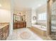 Luxurious bathroom featuring a soaking tub, granite counters, and tiled floor at 2300 Richardson Dr, Charlotte, NC 28211