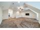 Spacious bonus room with neutral carpet, ceiling fan, and access to other living areas at 2300 Richardson Dr, Charlotte, NC 28211