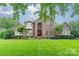 Brick two-story home featuring a manicured lawn and a symmetrical design, complete with mature landscaping at 2300 Richardson Dr, Charlotte, NC 28211