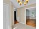 Hallway with tiled floors transitions to hardwood, showcasing neutral paint and stylish lighting at 2326 Horseshoe Bend Ne Rd, Hickory, NC 28601