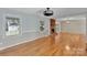 Sunlit living room with hardwood floors, featuring a brick fireplace and large windows at 2326 Horseshoe Bend Ne Rd, Hickory, NC 28601
