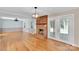 Bright living room featuring hardwood floors, brick fireplace, French doors, and a modern chandelier at 2326 Horseshoe Bend Ne Rd, Hickory, NC 28601