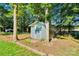 Storage shed in the backyard surrounded by mature trees and lush greenery at 2326 Horseshoe Bend Ne Rd, Hickory, NC 28601