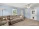 Inviting living room features neutral carpeting, a comfortable sofa, and ample natural light from the window at 2536 Cambridge Dr, Lancaster, SC 29720