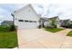 Beautiful white single-story home, showcasing its attached two-car garage and pristine driveway at 25952 Appleyard Ct, Lancaster, SC 29720