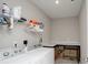 Functional laundry room with washer, dryer, shelving, and countertop space for folding clothes and storage at 25952 Appleyard Ct, Lancaster, SC 29720