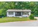 Newly renovated home with a well-maintained lawn, white painted brick, and stylish black accents at 3608 Crestridge Dr, Charlotte, NC 28217