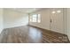 Well-lit living room with new wood-style floors and freshly painted white walls and trim at 3608 Crestridge Dr, Charlotte, NC 28217
