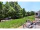 Serene backyard with a hammock, patio seating, and ample green space surrounded by trees at 4006 Centerview Dr, Indian Trail, NC 28079