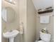 Clean powder room with pedestal sink, round mirror, shelf decor, and modern fixtures at 4006 Centerview Dr, Indian Trail, NC 28079