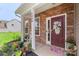 Welcoming front porch with a brick facade, decorative front door with floral wreath, and well-tended flower garden at 4006 Centerview Dr, Indian Trail, NC 28079