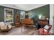 Warm living room featuring wood floors, with a piano and windows providing natural light at 4006 Centerview Dr, Indian Trail, NC 28079