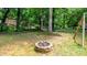 Backyard view of a fire pit and hammock, surrounded by lush greenery and mature trees at 411 Saint Andrews Rd, Statesville, NC 28625
