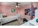 This bedroom is painted in a fun pink color with a ceiling fan, poster, and a dresser at 411 Saint Andrews Rd, Statesville, NC 28625