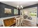 An open dining room with hardwood floors, chandelier and gray accent wall connects to the living room at 411 Saint Andrews Rd, Statesville, NC 28625