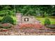 Charming stone entrance with manicured flowerbeds and lush greenery creating a welcoming appeal at 411 Saint Andrews Rd, Statesville, NC 28625