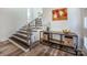 Inviting entryway featuring hardwood floors, modern console table, and stairs to the upper level at 411 Saint Andrews Rd, Statesville, NC 28625
