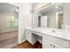 Bathroom vanity featuring dual sinks, wood look floors and gold fixtures at 4510 Glenlea Commons Dr, Charlotte, NC 28216