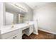 Bathroom vanity featuring dual sinks, wood look floors and gold fixtures at 4510 Glenlea Commons Dr, Charlotte, NC 28216