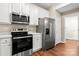 Modern kitchen is equipped with stainless steel appliances and white cabinets at 4510 Glenlea Commons Dr, Charlotte, NC 28216
