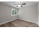 Neutral bedroom with a ceiling fan and natural light from a large window at 5008 Unaka Ave, Charlotte, NC 28205