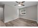 This bedroom features hardwood floors, a ceiling fan, a window, and an entry door at 5008 Unaka Ave, Charlotte, NC 28205