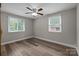 Neutral bedroom with a ceiling fan and natural light from two large windows at 5008 Unaka Ave, Charlotte, NC 28205