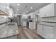 Bright kitchen features white cabinets, stainless steel appliances, granite countertops, and wood-look floors at 5008 Unaka Ave, Charlotte, NC 28205