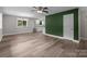 Inviting living area featuring modern flooring, a ceiling fan, and a decorative green accent wall at 5008 Unaka Ave, Charlotte, NC 28205
