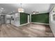 Open floorplan showcasing modern floors and an attractive, green, geometric accent wall adjacent to the kitchen at 5008 Unaka Ave, Charlotte, NC 28205